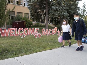 Adrien Borgia, 7, and Damien Borgia, 10, arrive for their first day of the new school year at St. Monica Elementary School on Tuesday August 31, 2021.
