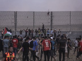 Palestinian protesters take part in a demonstration at the border fence with Israel, denouncing the Israeli siege of the Palestinian strip, during a protest to mark the 52nd anniversary of the burning of Al-Aqsa Mosque on August 21, 2021 in Gaza City, Gaza.