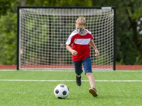 FILE: A child with mask and soccer ball.