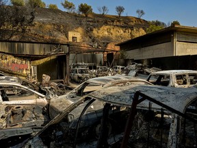 Burned cars at a workshop after a wildfire in  northern Athens, on August 4, 2021 in Athens, Greece. People were evacuated from their homes after a wildfire reached residential areas of northern Athens as fires broke out at the foot of Mount Parnes. Athens recored temperatures of 42 degrees Celsius (107.6 Fahrenheit).