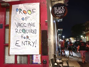 NEW ORLEANS, LOUISIANA - AUGUST 16: A sign reads 'Proof Of Vaccine Required For Entry' at a bar in the French Quarter on August 16, 2021 in New Orleans, Louisiana.