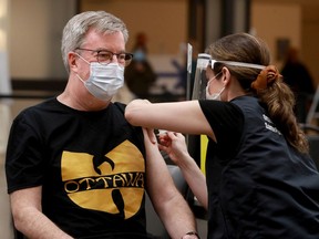 A May 5 file photo shows Ottawa mayor Jim Watson receiving his first dose of a COVID-19 vaccine at the Nepean Sportsplex.