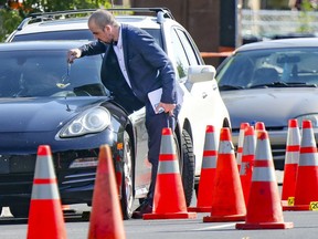 A Montreal police investigator examines a bullet hole in a car at the scene of a shooting in Montreal's Riviere-des-Prairies district on August 3, 2021.