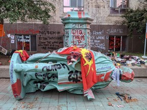 The toppled statue of Egerton Ryerson, one of the architects of indigenous boarding school system, is seen in Toronto on June 6.