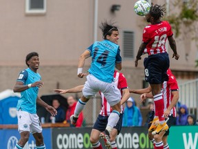HFX Wanderers FC Defender, Mateo Restrepo (14) and Atletico Ottawa Midfielder, Tevin Shaw (18) get up in the air for a ball during the match between HFX Wanderers FC and Atletico Ottawa at the Wanderers Grounds in Halifax, Nova Scotia.