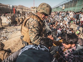 A U.S. Marine assists at an Evacuation Control Check Point during an evacuation at Hamid Karzai International Airport, Kabul, Afghanistan, on August 26, 2021. U.S. Marine Corps/Staff Sgt. Victor Mancilla/Handout photo