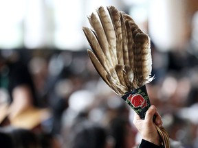 A woman holds eagle feathers during the closing ceremony of the National Inquiry into Missing and Murdered Indigenous Women and Girls in Gatineau, Que., on June 3, 2019.