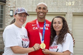 Olympic decathlon champion Damian Warner is flanked by his partner Jen Cotten, left, and mom Brenda Gillan at a celebration Tuesday night in London. Warner arrived in Canada on Monday and was reunited with his family, including his five-month-old son Theo. Warner said Theo's birth in March lifted his spirits during a difficult time training for the Tokyo 2020 Olympics. "It reset some things. Gave me some balance," he said.