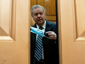 U.S. Senator Lindsey Graham (R-SC) puts a protective mask on as he arrives for the second impeachment trial of former U.S. President Donald Trump the U.S. Capitol in Washington, U.S., February 13, 2021.