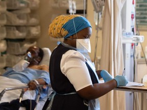 A hospital worker and COVID-19 patient are seen in in the resuscitation room at Khayelitsha Hospital, about 35 km from the centre of Cape Town, on December 29, 2020.