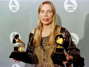 (FILES) In this file photo taken on February 27, 1996, Joni Mitchell holds two Grammy Awards at 38th Annual Grammy Awards in Los Angeles.