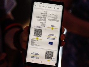 A boy shows his health pass as he arrives at a restaurant in Mont-Saint-Michel, in Normandy, northwestern France, on July 22, 2021.