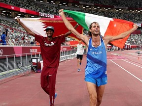 Gold medalist Mutaz Essa Barshim (L) of Team Qatar and silver medalist Gianmarco Tamberi of Team Italy celebrate on the track following the Men's High Jump Final during the Tokyo 2020 Olympic Games at the Olympic Stadium in Tokyo on August 1, 2021.