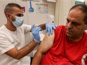 A health worker administers a dose of the Pfizer-BioNtech COVID-19 coronavirus vaccine on a man at the Clalit Health Services in a Palestinian neighbourhood.