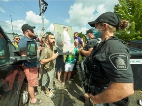 Protesters confront police during a Liberal campaign event with Prime Minister Justin Trudeau in Cambridge, Ont., on Aug. 29, 2021.