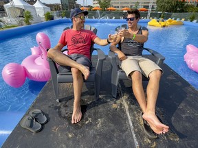 Buddies Robby Poirier (L) and Jonathan Vailancourt enjoy a beer poolside at the 10th annual Festibière de Gatineau on Thursday, Aug. 5, 2021.