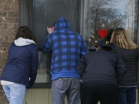 Family members look through the window of a long-term care home in Pickering.
