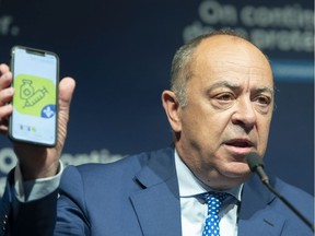 Quebec Health Minister Christian Dube shows an app on his phone as he announces details of the COVID-19 vaccination passport during a news conference Tuesday, August 10, 2021 in Montreal.THE CANADIAN PRESS/Ryan Remiorz ORG XMIT: RYR107-08-10