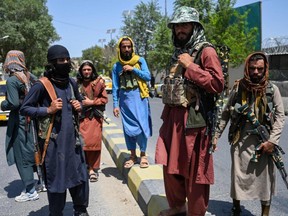 Taliban fighters stand guard along a street near the Zanbaq Square in Kabul on August 16, 2021.