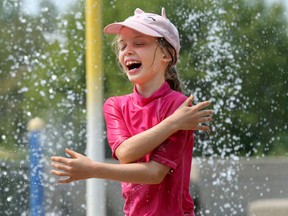 Melodie Rheaume, 9, beats the heat under the water jets at the Ken Ross Park splash pad in Barrhaven on Aug. 4, 2021.