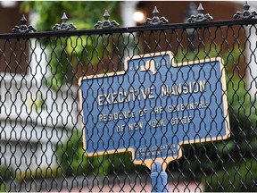 A sign is pictured through the fence at the Governor's Mansion, after an independent inquiry showed that Governor Andrew Cuomo sexually harassed multiple women and violated federal and state laws, in Albany, New York, U.S., August 7, 2021.