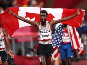 Tokyo 2020 Olympics - Athletics - Men's 5000m - Final - Olympic Stadium, Tokyo, Japan - August 6, 2021.  Silver medallist Mohammed Ahmed of Canada celebrates with his national flag
