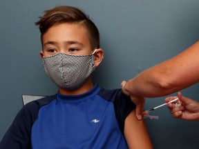 Owen Jung, 11, receives a Pfizer vaccine from Dr. Nili Kaplan-Myrth at her office in Ottawa.