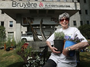 Kathleen Walker takes a break from gardening in front of the Élisabeth Bruyère Hospital in Lowertown on Monday. In late stages of terminal cancer, Walker and partner are redoing the front garden at the hospital, where she has spent time in palliative care.