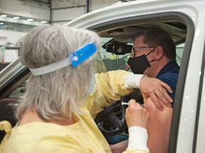 Saskatchewan Premier Scott Moe receives a dose of the Pfizer vaccine at a COVID-19 vaccination drive-thru clinic at Evraz Place in Regina on Thursday, April 15, 2021.