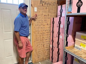 Michael Cinque, owner of the Amagansett Wine & Spirits, shows Reuters his board of hurricanes and "big ones" the store has survived going back to 1938, as the Hamptons prepares for Hurricane Henri's landfall.