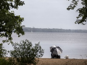 FILE: A man sits under an umbrella fishing in the  Ottawa River.