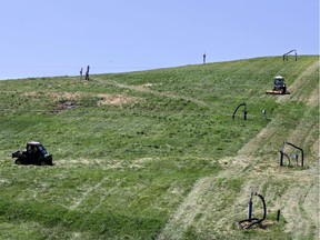 A worker cuts the "Carp Mountain" grass at Carp Dump in Carp, Ottawa, Thursday, July 24, 2014.