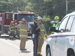 An OPP officer talks with firefighters from the Whitewater Region Fire Department and a member of the Renfrew County Paramedic Service at the scene of a motorcycle crash on Beachburg Road near Zion Line Wednesday morning, Sept. 1.
