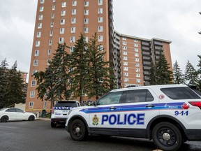 Police vehicles sit out the Jasmine Crescent apartment building after Anthony Aust, 23, fell to his death from a 12th-storey window in October 2020.