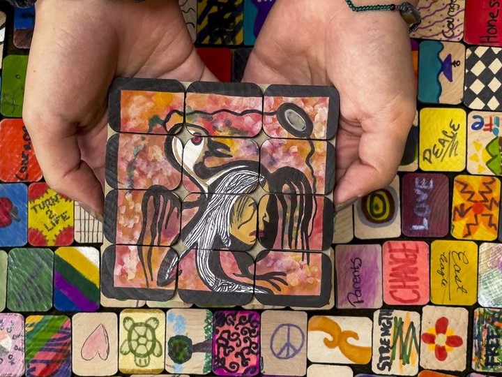  The hands of 17 year old Azia Seitcher, a member of the Nuu-Chah-Nulth First Nation from Vancouver Island, holds tiles painted by children that were being laid out in a memory labyrinth in preparation for September 30, 2021.