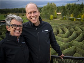 Mark Saunders, director of fun, and Angela Grant Saunders, director of beauty and flavour, (as stated in a recent press release) stand on the launch platform of the new 600-ft. zip line that flies high over the hedge mazes and ponds.