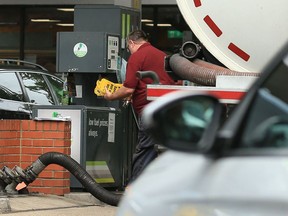 A tanker driver removes 'out of use' signs from pumps as fuel is pumped from his tanker into storage tanks at a BP petrol station in Lincolnshire. The UK government is poised to temporarily ease visa rules to attract more foreign lorry drivers, reports said Saturday, as it grapples with a growing shortage that has now hit fuel supplies.
