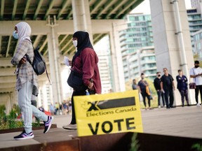 People line up outside a polling station to vote in Canada's federal election, in Toronto, Ontario, Canada September 20, 2021.