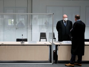 Two lawmakers stand next to the empty seat of the accused 96-year-old former secretary to the SS commander of the Stutthof concentration camp, at the Landgericht Itzehoe court, before a trial against her, in Itzehoe, Germany, Sept. 30.