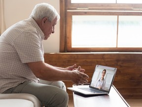 Elderly man make distant video call communicating with doctor online
