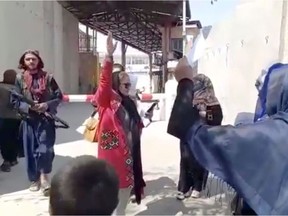 Files: Women chant slogans as they protest next to an armed man, in Kabul, Afghanistan September 3, 2021 in this still image obtained from a social media video. Facebook