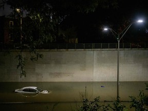 Floodwater surrounds a car on an expressway in Brooklyn, New York early on September 2, 2021, as flash flooding and record-breaking rainfall brought by the remnants of Storm Ida swept through the area.