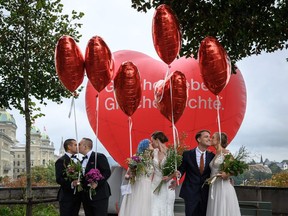Couples pose during a photo event during a nationwide referendum's day on same-sex marriage, in Swiss capital Bern on Sunday. Swiss voters have approved the government's plan to introduce same-sex marriage, according to the first projections following September 26 referendum triggered by opponents of the move.