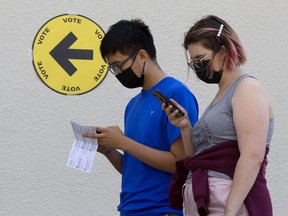 FILE: Voters wait in line at an Elections Canada advance poll.