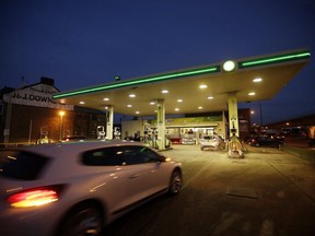 An automobile drives onto the forecourt of a gas station operated by BP Plc at night in London, U.K., on Tuesday, Jan. 14, 2014.
