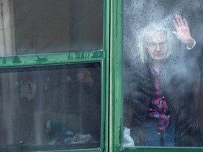 FILE PHOTO: A resident waves from her window at Residence Herron, a senior's long-term care facility, following a number of deaths since the COVID-19 outbreak, in the suburb of Dorval in Montreal Quebec.