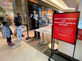 A security guard checks for proof of vaccination at the entrance to a food court during phase one of Ontario's vaccine certification program in Toronto, Ontario, Canada September 22, 2021.