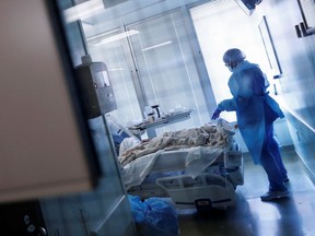 FILE: A Nurse treats a coronavirus disease (COVID-19) positive patient in his isolation room.