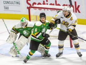 Sarnia Sting's Nolan DeGurse, right, battles London Knights' Denver Barkey in front of goalie Brett Brochu on Sept. 3 at Budweiser Gardens in London. The two teams were involved in a program called Hockey Fans in Training, in which 80 middle-aged men took part in discussions on healthy living and physical activity sessions.