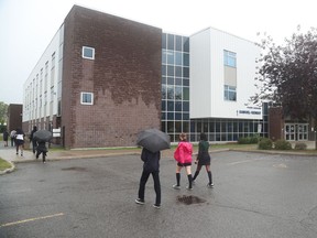 Students file into Samuel-Genest secondary school on Thursday. Samuel-Genest was one of seven schools where outbreaks were reported by the Conseil des écoles catholiques du Centre-Est, which opened schools on Aug. 31.